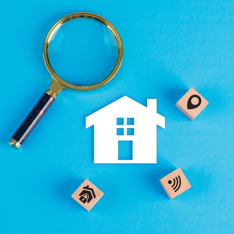 conceptual-real-estate-with-magnifying-glass-wooden-blocks-paper-home-icon-blue-table-flat-lay-scaled-r2ar9gj8cnm94tftn7g69tt2fl0ag0dlrvyrtwmudc